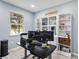Well-lit home office featuring built-in bookshelves and a modern adjustable desk at 3425 Middlebrook Pl, Harmony, FL 34773