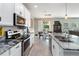 Well-lit kitchen with stainless steel appliances and marble countertops, with view to dining area at 3425 Middlebrook Pl, Harmony, FL 34773
