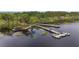 Beautiful lake view featuring a boat dock with slips and a wooden boardwalk surrounded by lush greenery at 3425 Middlebrook Pl, Harmony, FL 34773