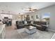 Spacious living room with a ceiling fan and large sectional sofa, and view to kitchen at 3425 Middlebrook Pl, Harmony, FL 34773
