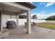 Covered brick patio with an outdoor dining set and a built-in grill at 3425 Middlebrook Pl, Harmony, FL 34773