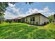 The backyard features a lush green lawn, neatly trimmed hedges, and a screened-in lanai, perfect for outdoor living at 352 Alicante Ct, Davenport, FL 33837