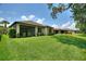 Expansive backyard featuring lush green grass, manicured hedges, and a screened-in lanai for outdoor enjoyment at 352 Alicante Ct, Davenport, FL 33837