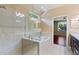 Bright bathroom featuring a glass-enclosed shower and tub combination, with neutral tile and granite countertops at 352 Alicante Ct, Davenport, FL 33837