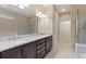 Bathroom featuring double vanity, a large mirror, and a walk-in shower with glass doors and a separate tub at 352 Alicante Ct, Davenport, FL 33837