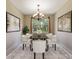 Elegant dining room with a chandelier, neutral color palette, and large framed artwork on the walls at 352 Alicante Ct, Davenport, FL 33837
