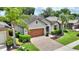 Charming home with a well-manicured lawn, mature landscaping, a brick driveway, and a two-car garage at 352 Alicante Ct, Davenport, FL 33837