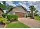 Charming home with a well-manicured lawn, mature landscaping, a brick driveway, and a two-car garage at 352 Alicante Ct, Davenport, FL 33837
