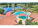 Overhead view of a pool with shade structures, umbrellas, lounge chairs, and lush landscaping at 352 Alicante Ct, Davenport, FL 33837