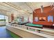 A spacious recreation room featuring two pool tables, seating areas, and large windows with outdoor views at 352 Alicante Ct, Davenport, FL 33837