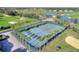 Aerial view of tennis and pickleball courts surrounded by palm trees and lush greenery at 352 Alicante Ct, Davenport, FL 33837