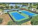Aerial view of well-maintained community tennis courts, set against a picturesque lakeside backdrop at 352 Alicante Ct, Davenport, FL 33837