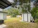 View of the backyard with a metal storage shed and a chain-link fence on a sunny day at 4760 Danzig Ct, Orlando, FL 32811