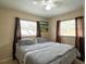 Bedroom featuring two windows with curtains and a large bed at 4760 Danzig Ct, Orlando, FL 32811