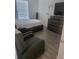 Neutral bedroom with laminate flooring, featuring a queen bed, dresser, TV, and a comfortable armchair at 4819 Apple Blossom Ln, St Cloud, FL 34771