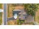 Aerial shot of the property showcasing the home's roofline, driveway, and surrounding yard with mature trees at 4885 Meadow Dr, St Cloud, FL 34772