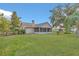 Expansive backyard showcasing the home's exterior, lush lawn, and mature trees at 4885 Meadow Dr, St Cloud, FL 34772