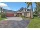 Inviting home showcases a red garage door, well-maintained landscaping, and a spacious driveway at 4885 Meadow Dr, St Cloud, FL 34772