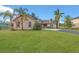 Charming single-story home featuring a lush front lawn and mature palm trees under a bright blue sky at 4885 Meadow Dr, St Cloud, FL 34772