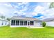 Backyard view featuring a well maintained lawn and enclosed sunroom at 5426 Astor St, Leesburg, FL 34748