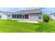 Grassy backyard with a small patio area and screened in sunroom for outdoor enjoyment at 5426 Astor St, Leesburg, FL 34748
