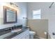 Well-lit bathroom with a black granite countertop vanity and shower at 5426 Astor St, Leesburg, FL 34748