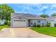 Single-story home with a white garage door, well-maintained lawn, and a concrete driveway at 5426 Astor St, Leesburg, FL 34748