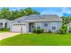 Charming single-story home featuring a well-maintained lawn and a white garage door at 5426 Astor St, Leesburg, FL 34748