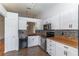 Bright kitchen featuring white cabinets, mosaic backsplash, granite countertops, and steel appliances at 5426 Astor St, Leesburg, FL 34748