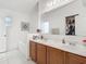 Bright bathroom featuring a double sink vanity, large mirror, and tub at 5577 Sycamore Canyon Dr, Kissimmee, FL 34758