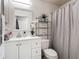 Well-lit bathroom featuring white vanity, modern fixtures, and shower with curtain at 5577 Sycamore Canyon Dr, Kissimmee, FL 34758
