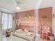 Pink themed bedroom has unique decor, window for natural light, and tile floors at 5577 Sycamore Canyon Dr, Kissimmee, FL 34758