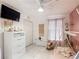 Charming bedroom with white tile floors, ceiling fan, and natural light from the window at 5577 Sycamore Canyon Dr, Kissimmee, FL 34758