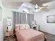 Cozy bedroom features a ceiling fan, wood-look floors, and natural light from the window at 5577 Sycamore Canyon Dr, Kissimmee, FL 34758