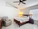 Bright bedroom with cozy chair, ceiling fan and natural light from the windows at 5577 Sycamore Canyon Dr, Kissimmee, FL 34758