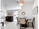 Dining area with a glass table, four chairs, neutral decor, and bright white walls at 5577 Sycamore Canyon Dr, Kissimmee, FL 34758