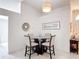 Dining area featuring a glass table, four chairs, and neutral decor near the home's entrance at 5577 Sycamore Canyon Dr, Kissimmee, FL 34758