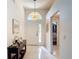 Bright foyer with white walls, decorative console table, and a decorative light fixture above the door at 5577 Sycamore Canyon Dr, Kissimmee, FL 34758