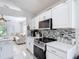 Bright kitchen showcases white cabinetry, stainless steel oven, modern backsplash, and stone countertops at 5577 Sycamore Canyon Dr, Kissimmee, FL 34758