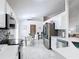 Open kitchen features stainless appliances, modern backsplash, and a view into the breakfast nook with tile flooring at 5577 Sycamore Canyon Dr, Kissimmee, FL 34758