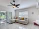 Bright living room with tile floors features a ceiling fan and sliding glass doors leading to a lanai at 5577 Sycamore Canyon Dr, Kissimmee, FL 34758