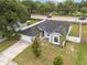 Overhead view of gray house with lush lawn, mature trees and white picket fence at 5642 Chukar Dr, Orlando, FL 32810