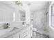 Modern bathroom with double vanity, marble-look tiled shower, and gray wood-look flooring at 5642 Chukar Dr, Orlando, FL 32810
