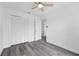 This bedroom features gray wood-look flooring, a ceiling fan, and a double-door closet at 5642 Chukar Dr, Orlando, FL 32810