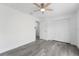 This bedroom features gray wood-look flooring, a ceiling fan, and a double-door closet at 5642 Chukar Dr, Orlando, FL 32810