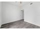 Bright, minimalist bedroom with gray wood-look flooring and a bright white door at 5642 Chukar Dr, Orlando, FL 32810