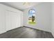 The bedroom features gray wood-look flooring, a ceiling fan, and a large arched window at 5642 Chukar Dr, Orlando, FL 32810