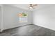 Minimalist bedroom featuring a ceiling fan, gray wood-look flooring, and a bright window at 5642 Chukar Dr, Orlando, FL 32810