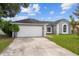 Gray home with an attached garage and a well manicured green lawn at 5642 Chukar Dr, Orlando, FL 32810