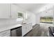 Updated kitchen with white cabinets, stainless appliances, gray floors, and modern lighting at 5642 Chukar Dr, Orlando, FL 32810